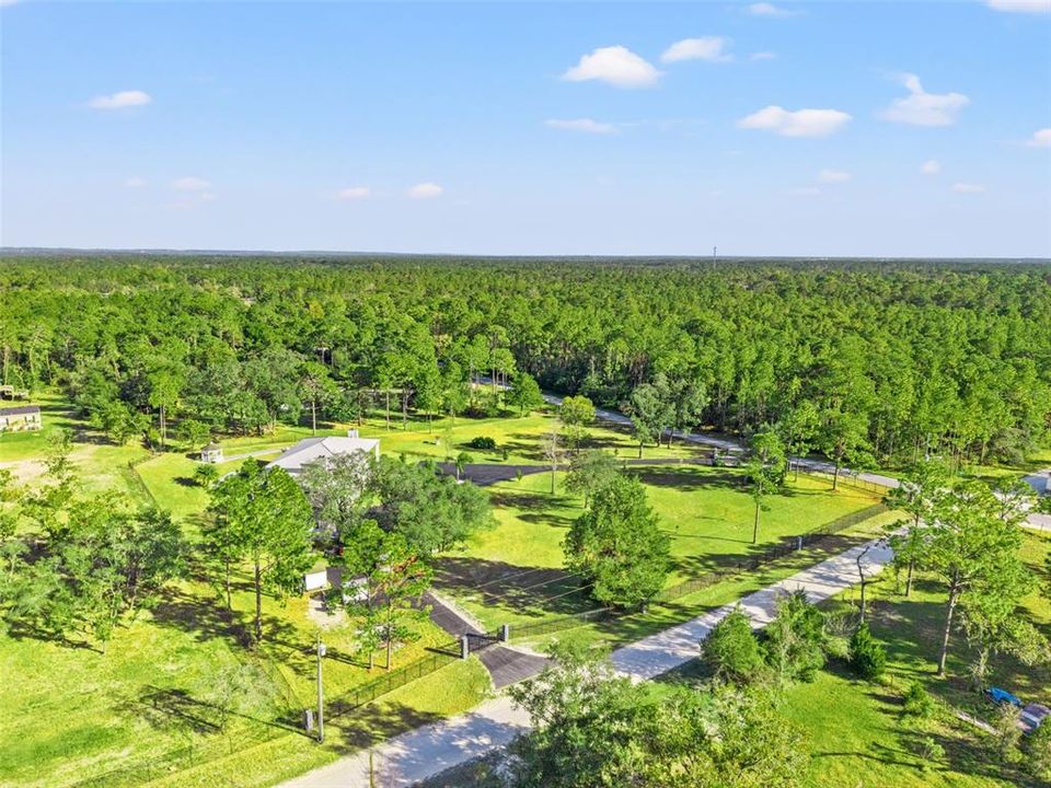 Aerial view of this Colonial-inspired estate, designed with the grandeur reminiscent of the iconic “White House.” Set on a private 2.40-acre property