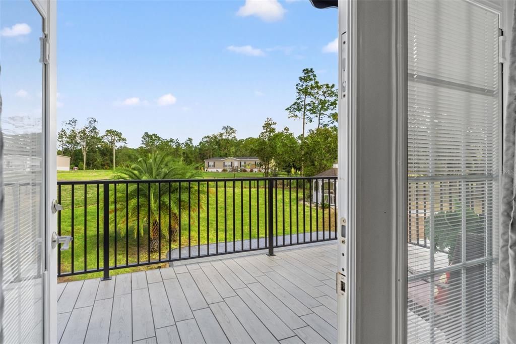 A private balcony fron the masters suite featuring new tile, railing, and an awning, offering serene views of the pool for ultimate relaxation.