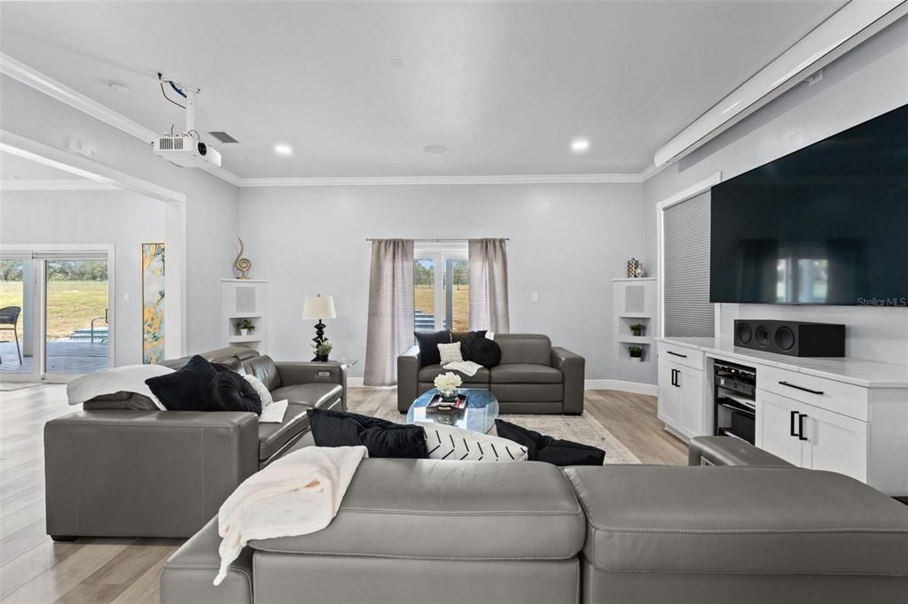 Living Room with built in speaker and sliding doors that lead to the pool and backyard oasis