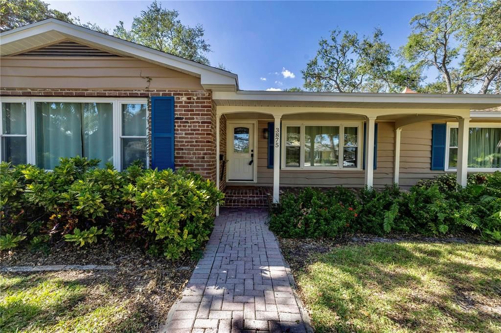 Wide cedar plank siding with a charming brick front porch.