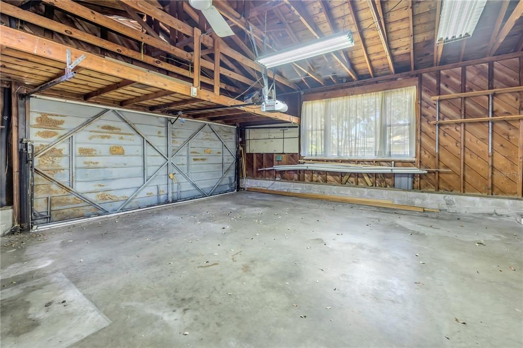 Oversized 2 car garage with ample overhead storage, tool closet and work bench.