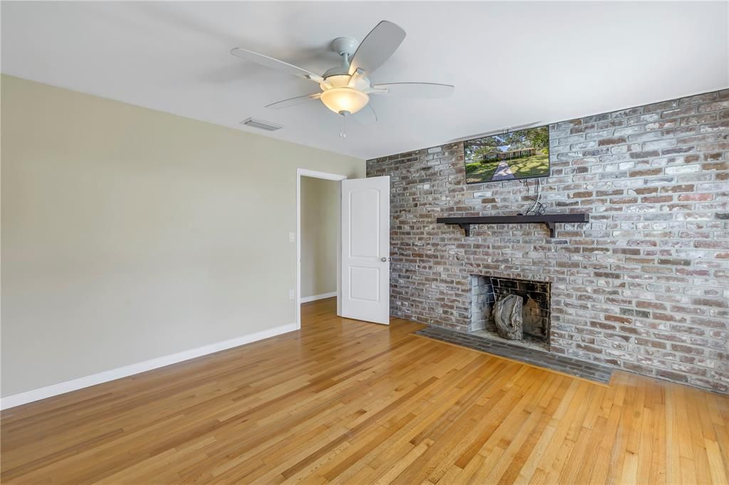 The primary suite includes a brick accent wall and a wood-burning fireplace.