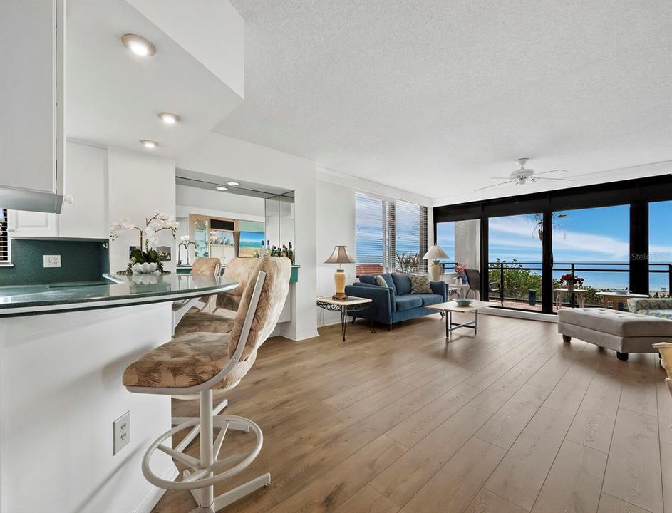 The breakfast bar connecting the kitchen to the great room offers overhead recessed lighting.