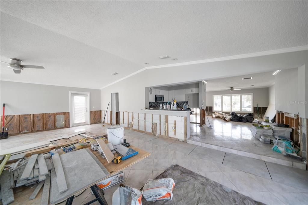 Great room with vaulted ceiling, new tile and high breakfast bar. Drywall to be installed, textured and painted.