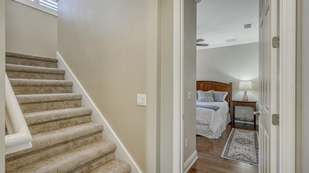 Stairs to upper level bonus room near 3rd bedroom