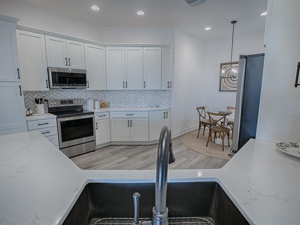 LOVELY QUARTZ COUNTERTOPS AND TILE BACKSPLASH.