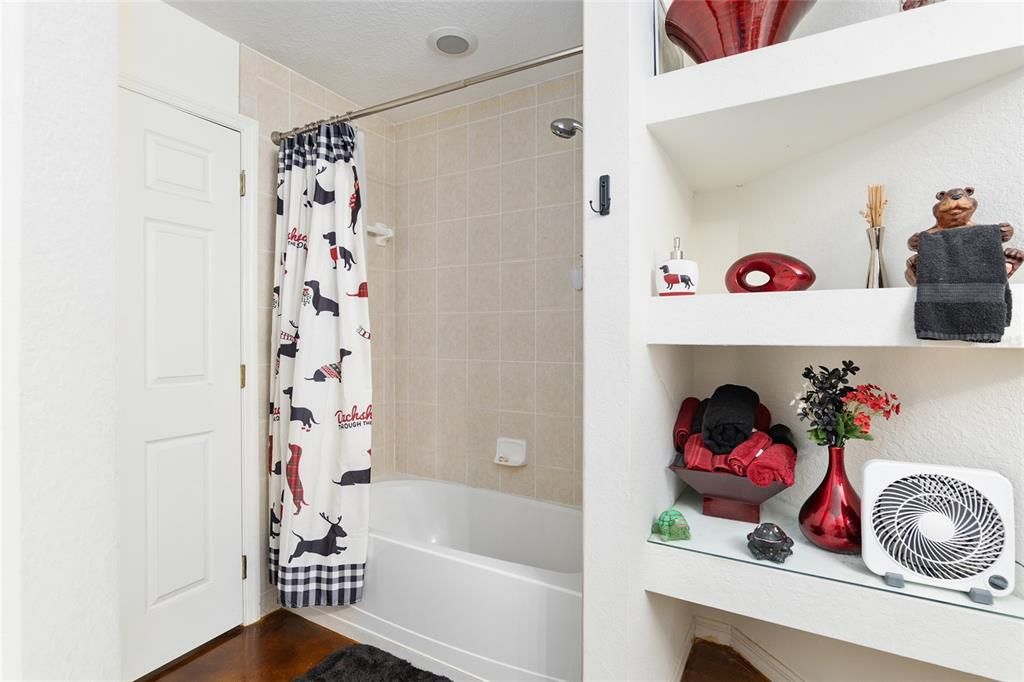 Hallway bath with shower/tub combo and shelving