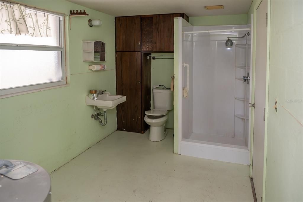 12' x 7' Inside Utility/ Laundry Room.  Features a walk-in shower, toilet and sink, hook-up for a washer and dryer, and houses the electric water heater.