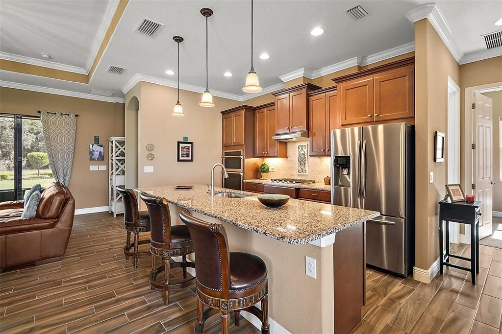 The open great room and multi-level granite countertops at the island keep the chef part of the action.