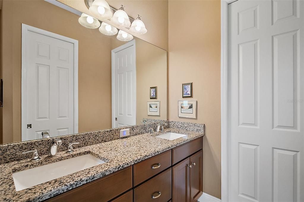 Owner's Suite Spit Vanity oversized mirror and door to the walk-in closet.