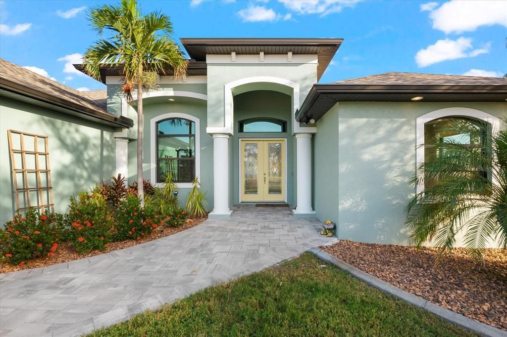 Elegant front entry featuring a grand entrance and mature landscaping