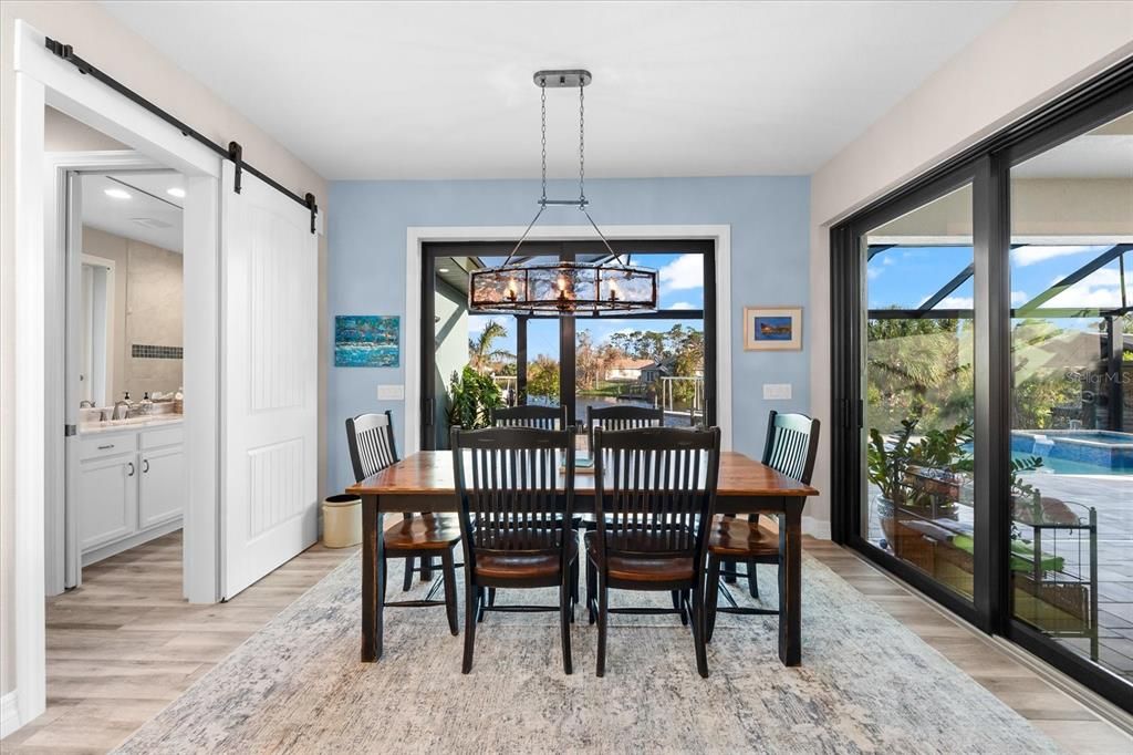 Elegant dining room with double sliders, inviting natural light and seamless indoor-outdoor flow