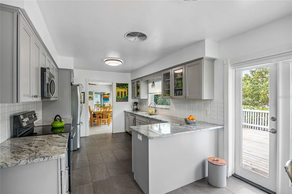 There is a Breakfast Nook at the end of the Kitchen, perfect for quick bite or enjoying your morning coffee.    The  French Doors lead out to the deck, one of several outdoor lounging areas at this home!