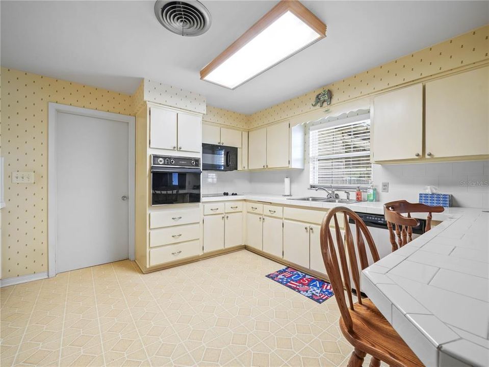 KITCHEN WITH DOOR LEADING TO PANTRY, 1/2 BATH, STORAGE CLOSET AND LAUNDRY ROOM