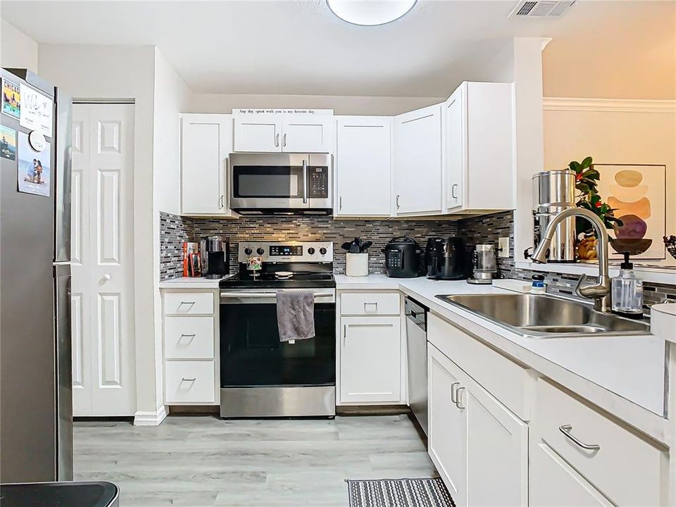 Stainless steel appliances, including a modern refrigerator, stove, microwave, and dishwasher.