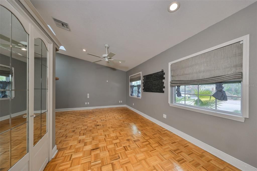 Bedroom #5 with mirrored closet doors to the left and windows facing the front of the house