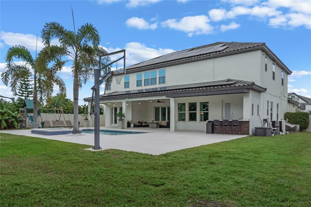 Expansive backyard with view of half court basketball area and summer kitchen