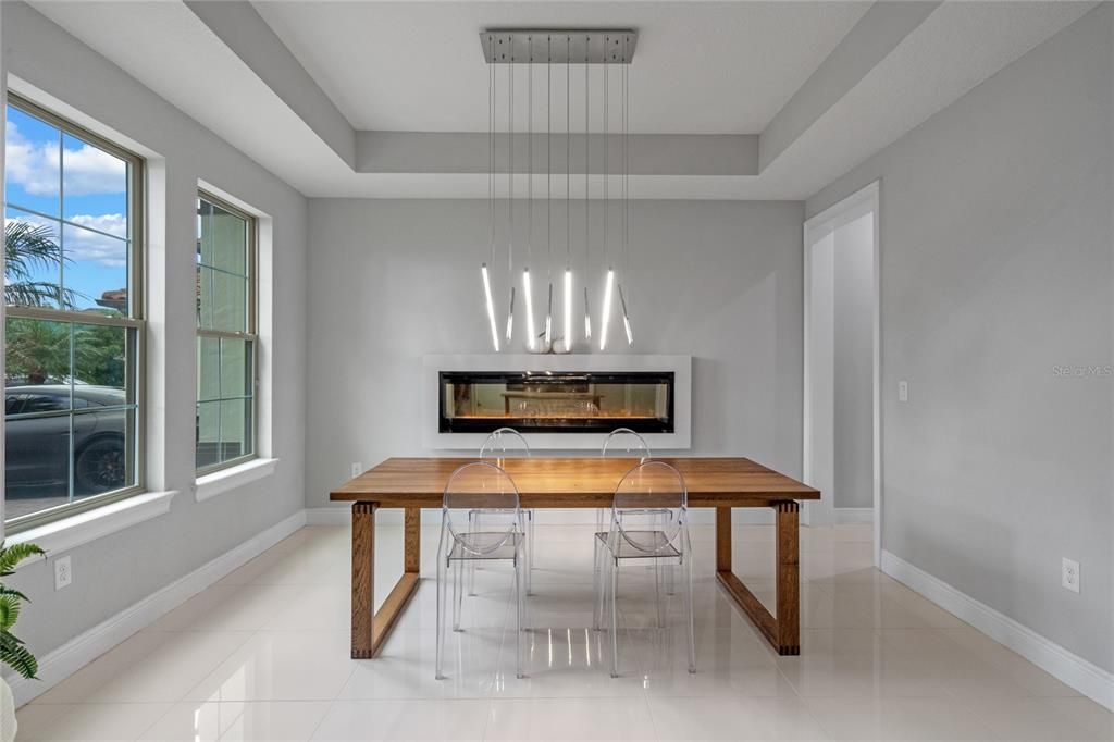 The formal dining room is located in the front of the home and features custom lighting and a custom ventless glass fireplace.