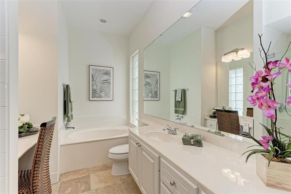 Second bathroom featuring soaking tub, and two vanity areas.