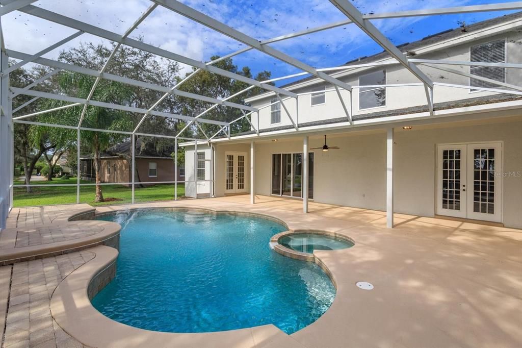 Screen enclosed pool and spa with built in cleaning system