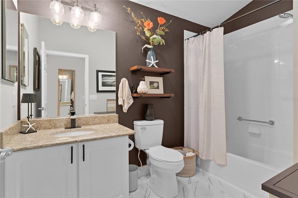 The guest bathroom with a tub/shower combo  with SOLAR TUBES