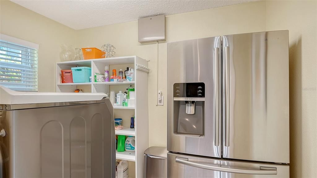 the refrigerator has been moved into the open utility room for more space in your kitchen... it's genius!