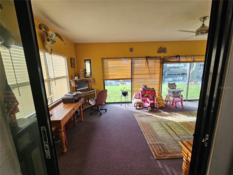 Looking out of the primary bedroom into the Floridaroom and overlooking the canal.