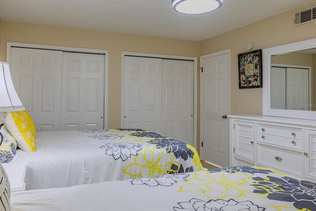 Two closets in guest room with custom organization system as well.