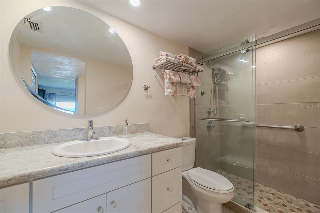 Primary bath with tiled shower and glass doors