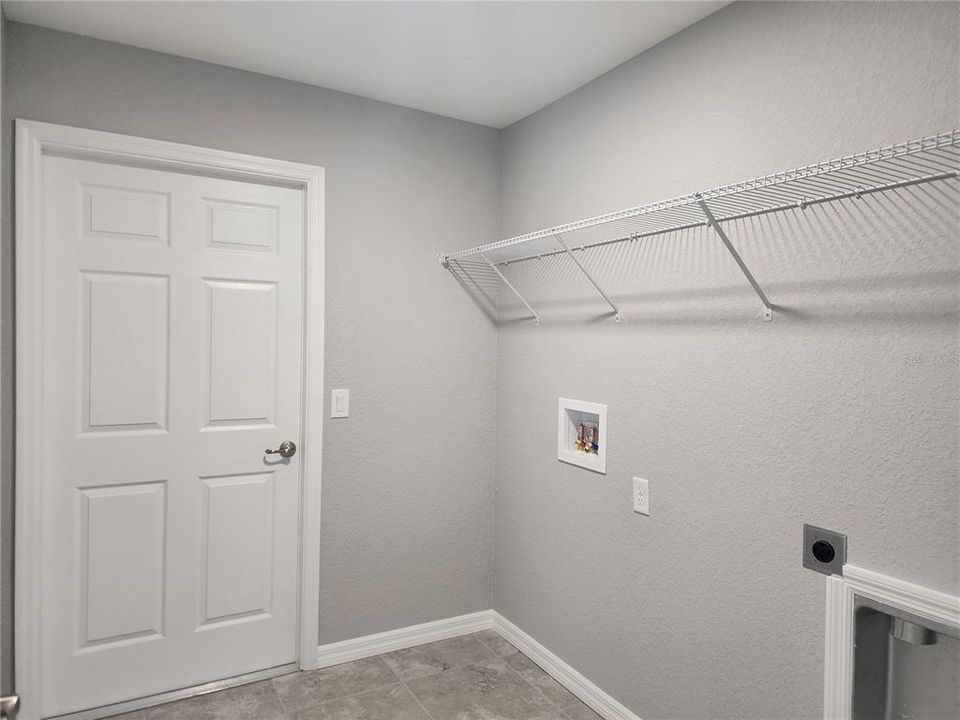 Inside laundry room with linen closet and washer and dryer hook-ups