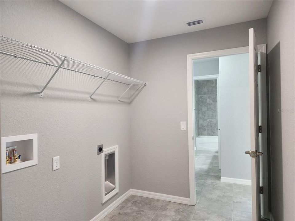 Inside laundry room with linen closet and washer and dryer hook-ups