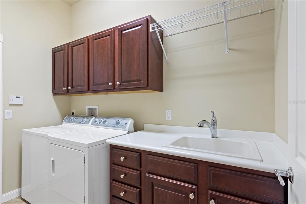 Laundry Room with Washer, Dryer, Cabinets, and Sink