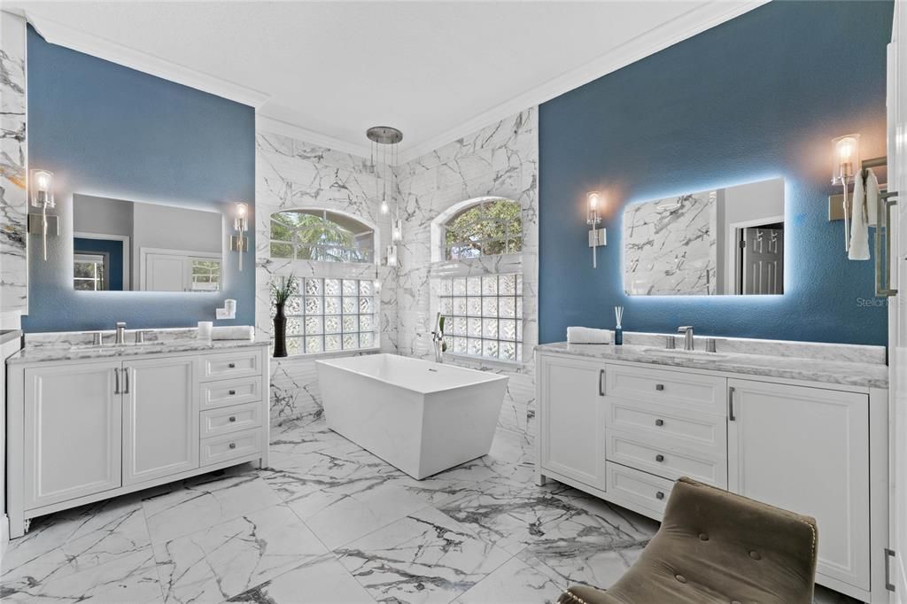 Primary bathroom featuring soaking tub and dual vanities