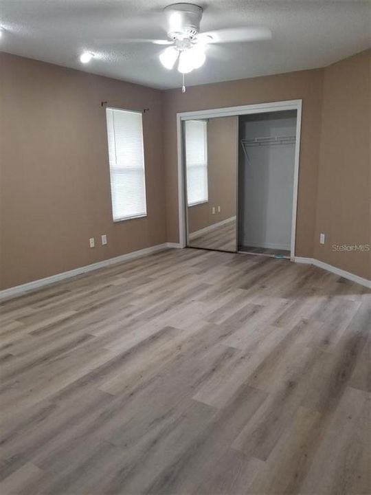 Primary bedroom - new flooring and fan - room for your King Sized bed!