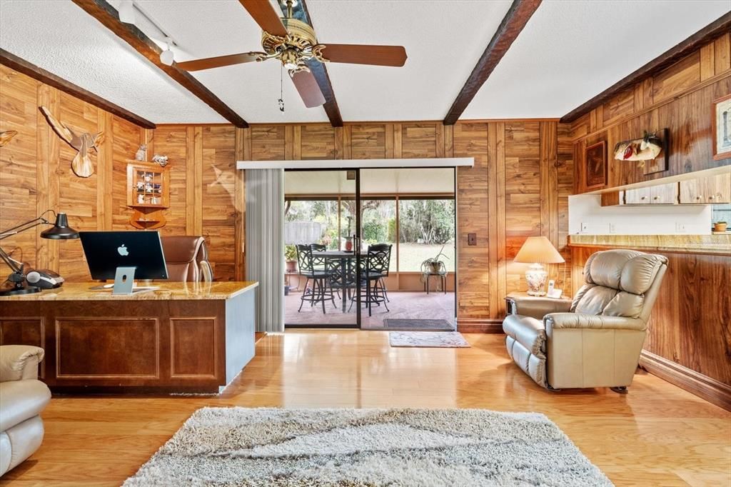 Sunken Family Room w/ Hardwood Floors, Beamed Ceiling, Plank Style Paneling & Slider to the Covered, Screened Lanai