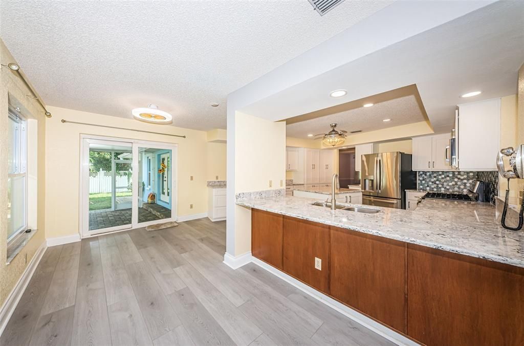 Breakfast bar and eating space just off the kitchen and family room with hurricane sliders to large screened backporch