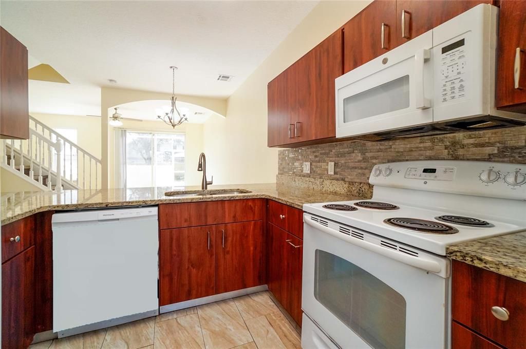 large eat in kitchen with tiled backsplash and granite countertop