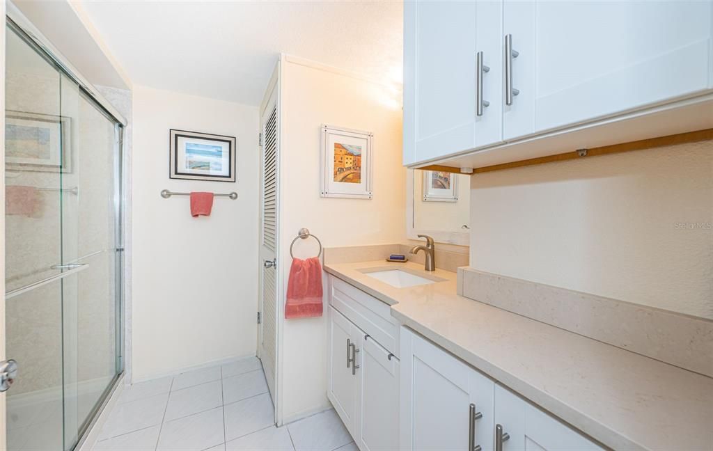 REMODELED BATHROOM with white shaker cabinets and quartz countertop