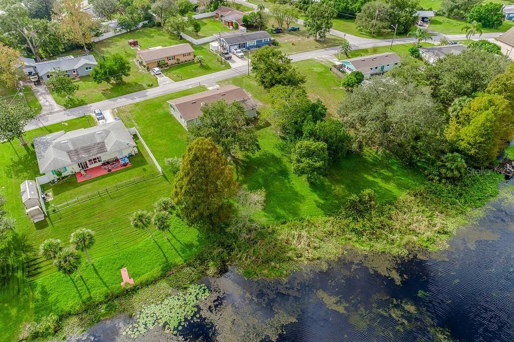 On a large .39 ACRE LOT with NO HOA and LAKE VIEWS this functional floor plan delivers SPLIT BEDROOMS, a generous FLORIDA ROOM with a fabulous wall of windows, UPDATED EAT-IN KITCHEN, hardwood floors and a NEWER ROOF (2022).