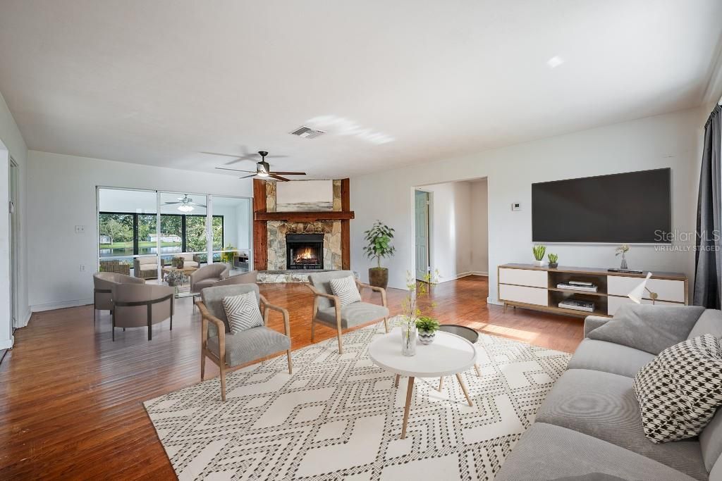 A large picture window in the living area lets the natural light pour in, creating a warm and inviting atmosphere that pairs perfectly with the floor to ceiling corner FIREPLACE. Virtually Staged.