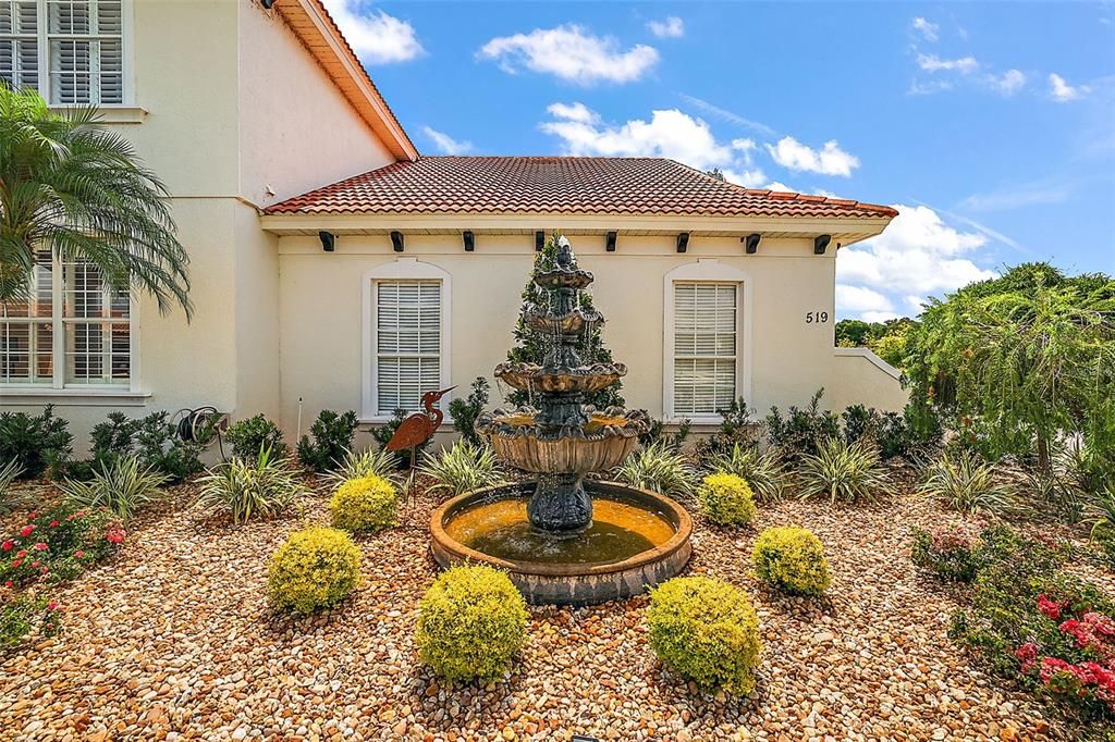 A tranquil fountain greets guests along a paver path.