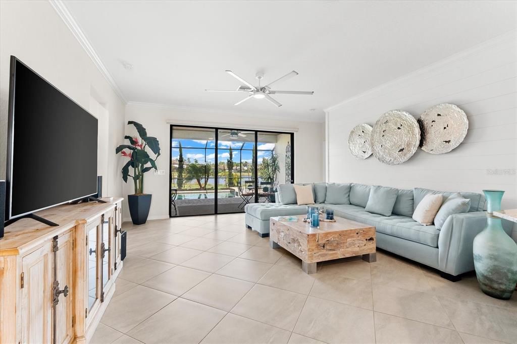 Living room with beautiful pool and water view.  Upgraded large ceiling fan.