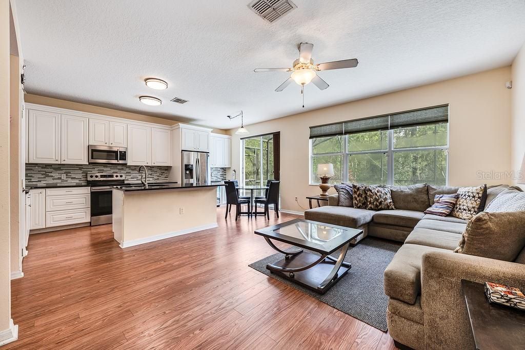 A large window frames the WOODED VIEW perfectly and sliding glass doors open up the SCREENED POOL and SPA!