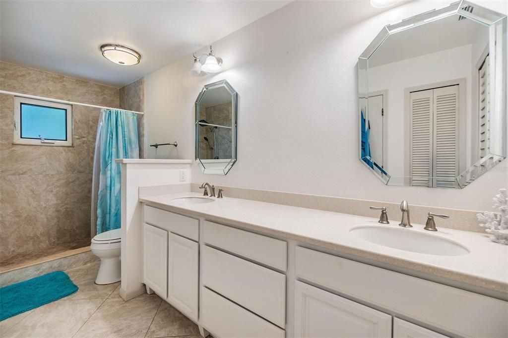 Primary ensuite bathroom with large double sink vanity, and stand-up shower