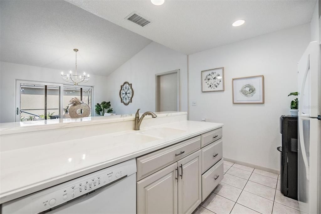 Kitchen is light and bright with extended elevated countertop for pull up seating.