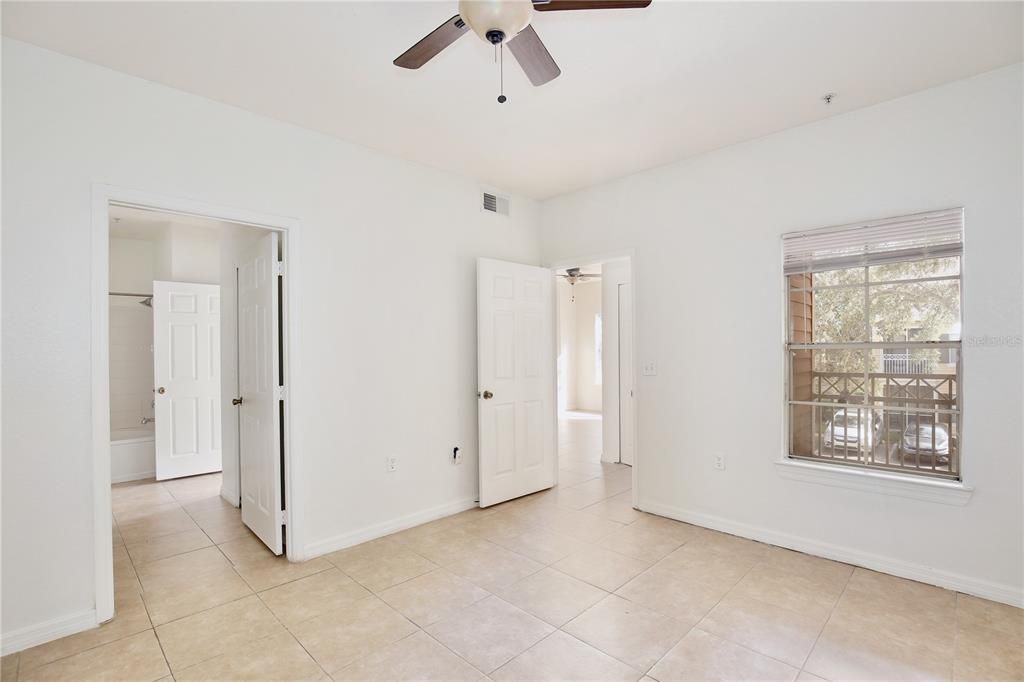 Lots of natural light in primary bedroom.Ceramic tile and fan for comfort.