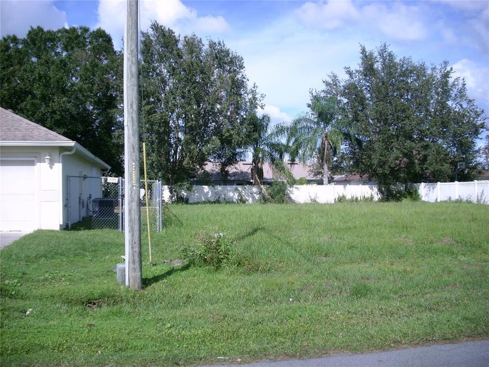 Left edge of photo is Neighbor's house. Both side and rear Neighbors fence is in the photo.