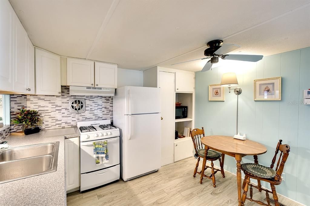 Updated kitchen with decorative cabinetry,  backsplash and gas stove