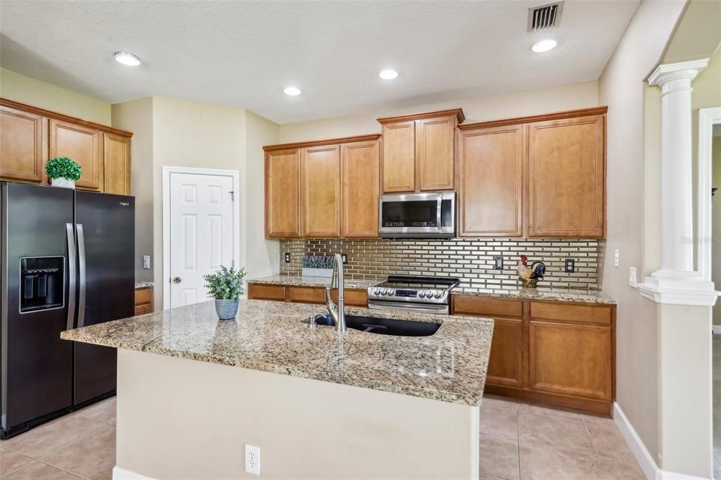 Open kitchen with spacious island, stainless steel appliances and granite counter tops