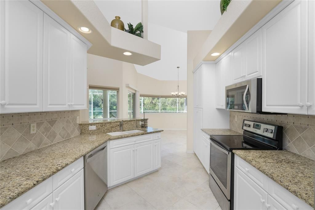 Kitchen complete with matching Whirlpool appliances, granite counters & recessed lighting.